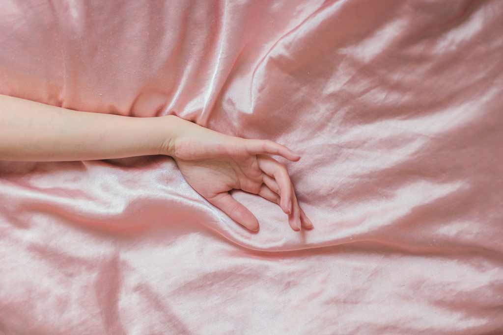 PLEASEPINCHMEHARD rich results for free short erotic stories image shows woman hand lying on pink satin bedsheets