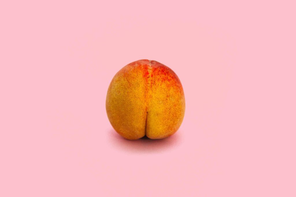 Image of a peach that looks like a bum to depict anal sex in a short erotic story. On a pink background