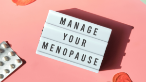 A photo of a light box with the words manage your menopause on a peach background