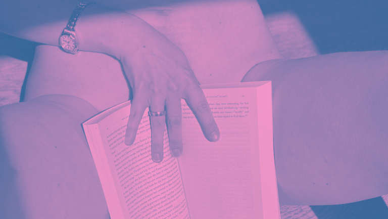 Photo of a naked woman with a book covering her vulva