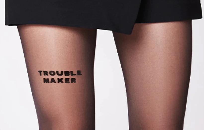 Photo by Saint Sass with their tights and the saying "TROUBLE MAKER"
