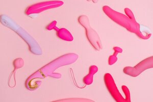 A photo of diverse sex toys on a pink background for an article by Lisa Opel for pleasepinchmehard SHORT READS about hygiene and mold regarding sex toys