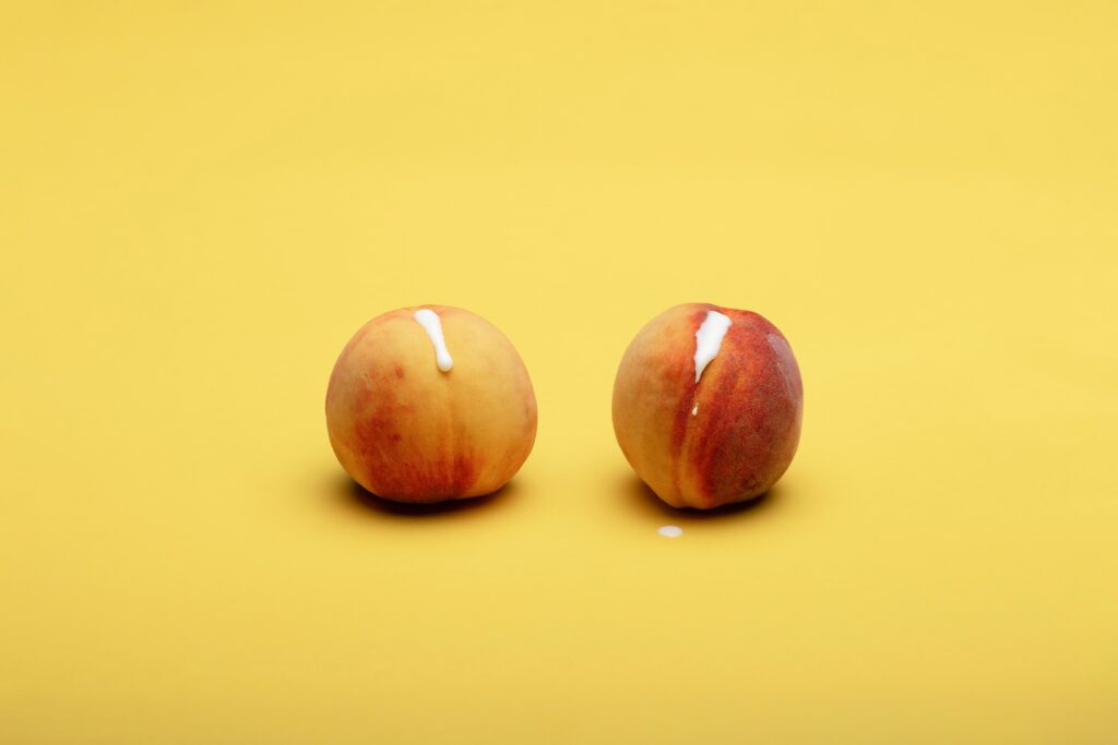 Photo of two peaches with cream leaking out of them