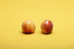 Photo of two peaches with cream leaking out of them