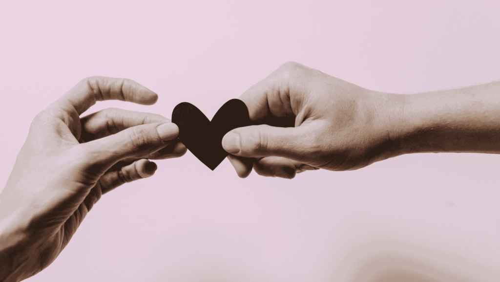 Photo of hands holding a heart for an article about attachment styles in relationships