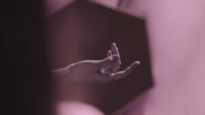 A hand suggestively in a mirror, fingers slightly spread, capturing a moment of intimacy and reflection.