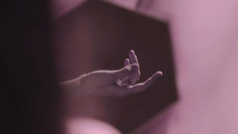 A hand suggestively in a mirror, fingers slightly spread, capturing a moment of intimacy and reflection.